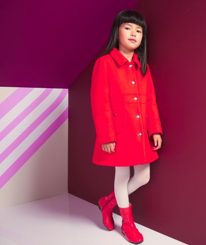 Ein Mädchen mit einem roten Mantel und roten Stiefeln