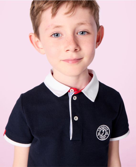 Junge in Schuluniform mit marineblauem Poloshirt mit weißem Kragen